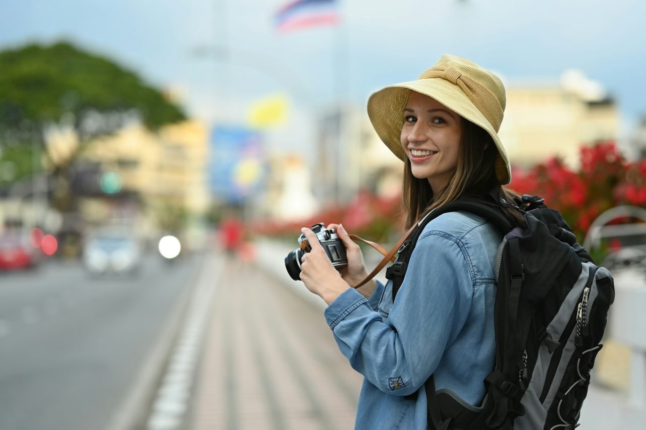 happy caucasian female traveler with backpack on holiday vacation trip in thailand